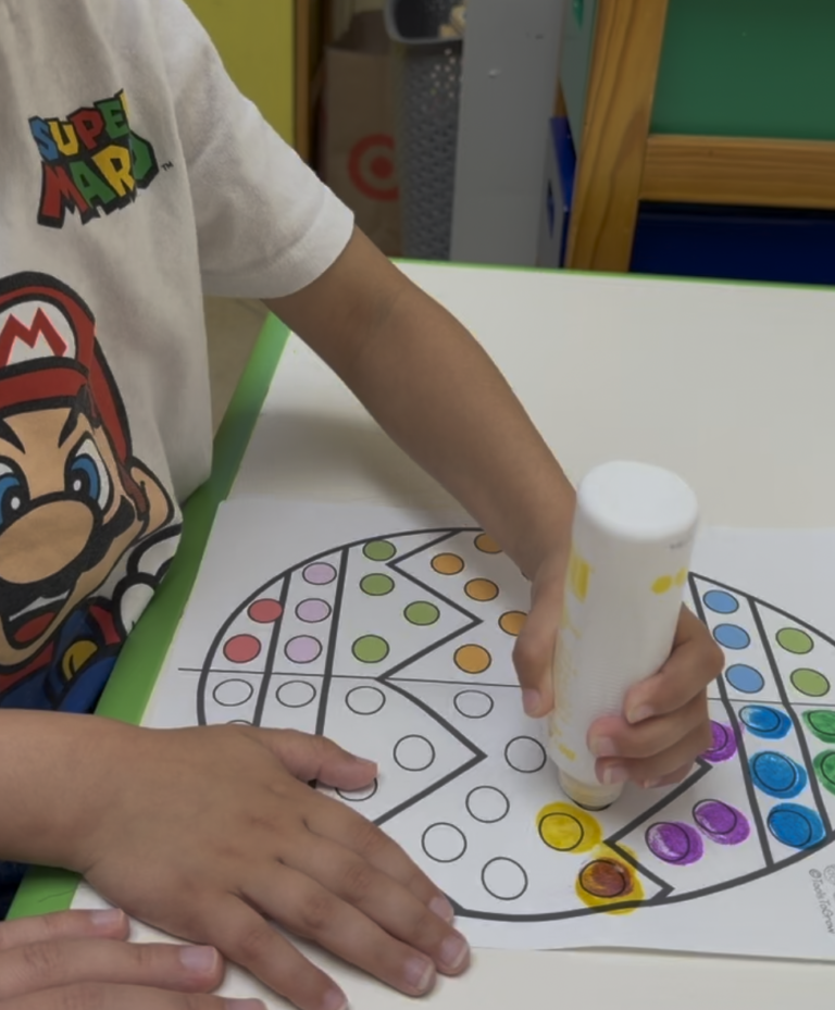Child using a dot marker on a coloring worksheet.