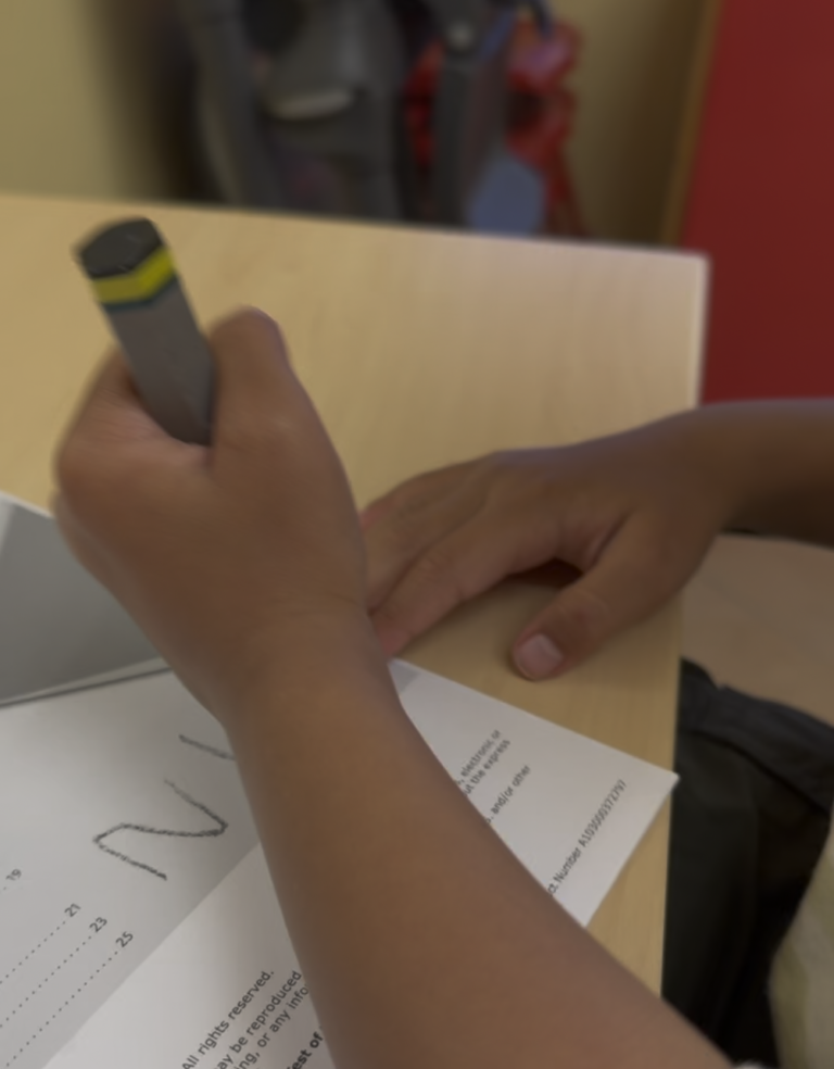 Hand tracing a worksheet with a marker.